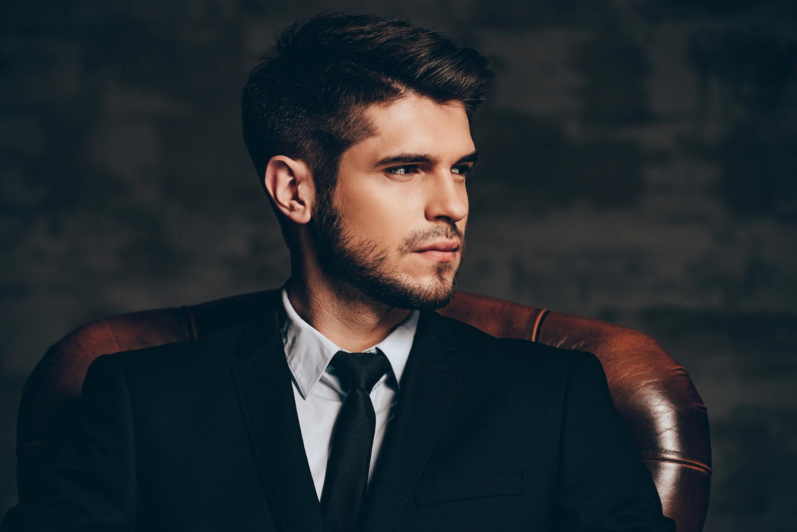 Well-groomed man in a suit relaxing in an ALPHA Men's Spa® lounge
